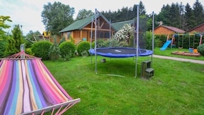A grassy backyard with a trampoline, a swing set, and a hammock. - Die Ostsee by Interhome (Rusinowo)