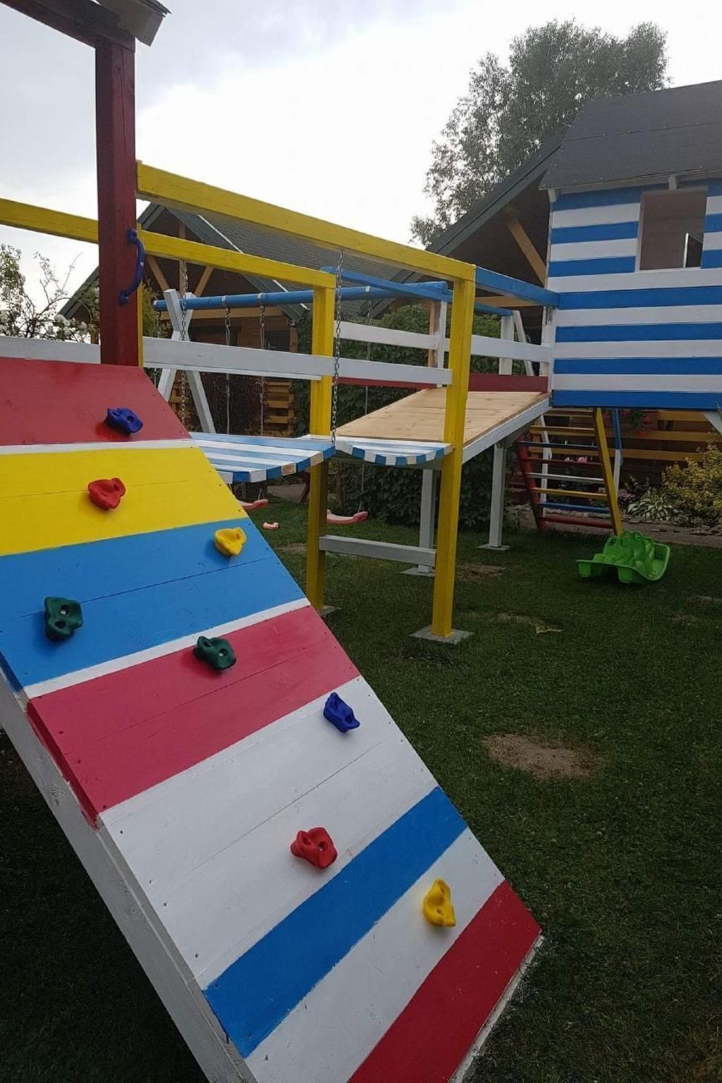 A playground with a climbing wall and a slide.