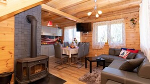 A cozy cabin interior with a wood stove, dining area, and seating. - Die Ostsee by Interhome (Rusinowo)