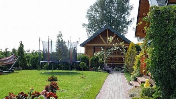 A pathway leading to a wooden cabin with a garden and a trampoline. - Die Ostsee by Interhome (Rusinowo)