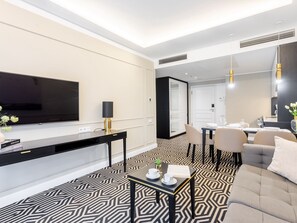 A modern hotel room with a large flat-screen TV, a desk with a lamp, a dining area with chairs, and a patterned floor. - Stilvoll eingerichtete Ferienwohnung am Meer by Interhome (Swinoujscie)