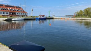 A marina with boats docked, a lighthouse, and a building with a red roof. - Haus Kranich by Interhome (Nowe Warpno)