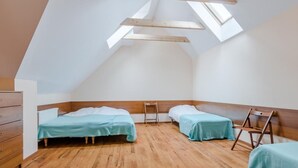 A small, triangular attic bedroom with two beds, wooden beams, and skylights. - "Apartment4" mit Garten by Interhome (Rowy)