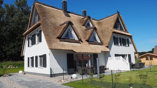 A modern house with a unique triangular roof design, large windows, and a well-maintained lawn. - Traumbrise by Interhome (Rerik)