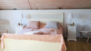 A bedroom with a bed, two bedside tables, a chair, and a wooden ceiling. - an der Kaschubischen Seenplatte by Interhome (Sierakowice)