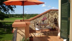 A patio with a table and chairs, an umbrella, and potted plants. - an der Kaschubischen Seenplatte by Interhome (Sierakowice)