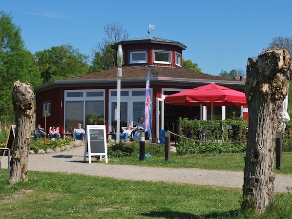 A red building with a tower, outdoor seating, and a signboard. - mit Hund by Interhome (Buchholz)