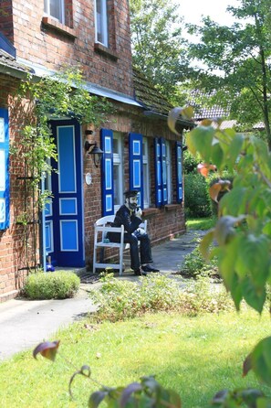 A brick building with blue shutters and a white bench outside.