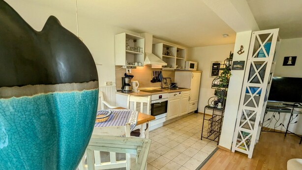 A kitchen with white cabinets, a coffee maker, and a microwave. - Apartment 55qm by Interhome (Ahrenshoop)