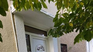 A white door with a small window, a mailbox, and a number '61' sign on the wall. - Schönes Haus in Orpington by Interhome (St. Mary Cray)