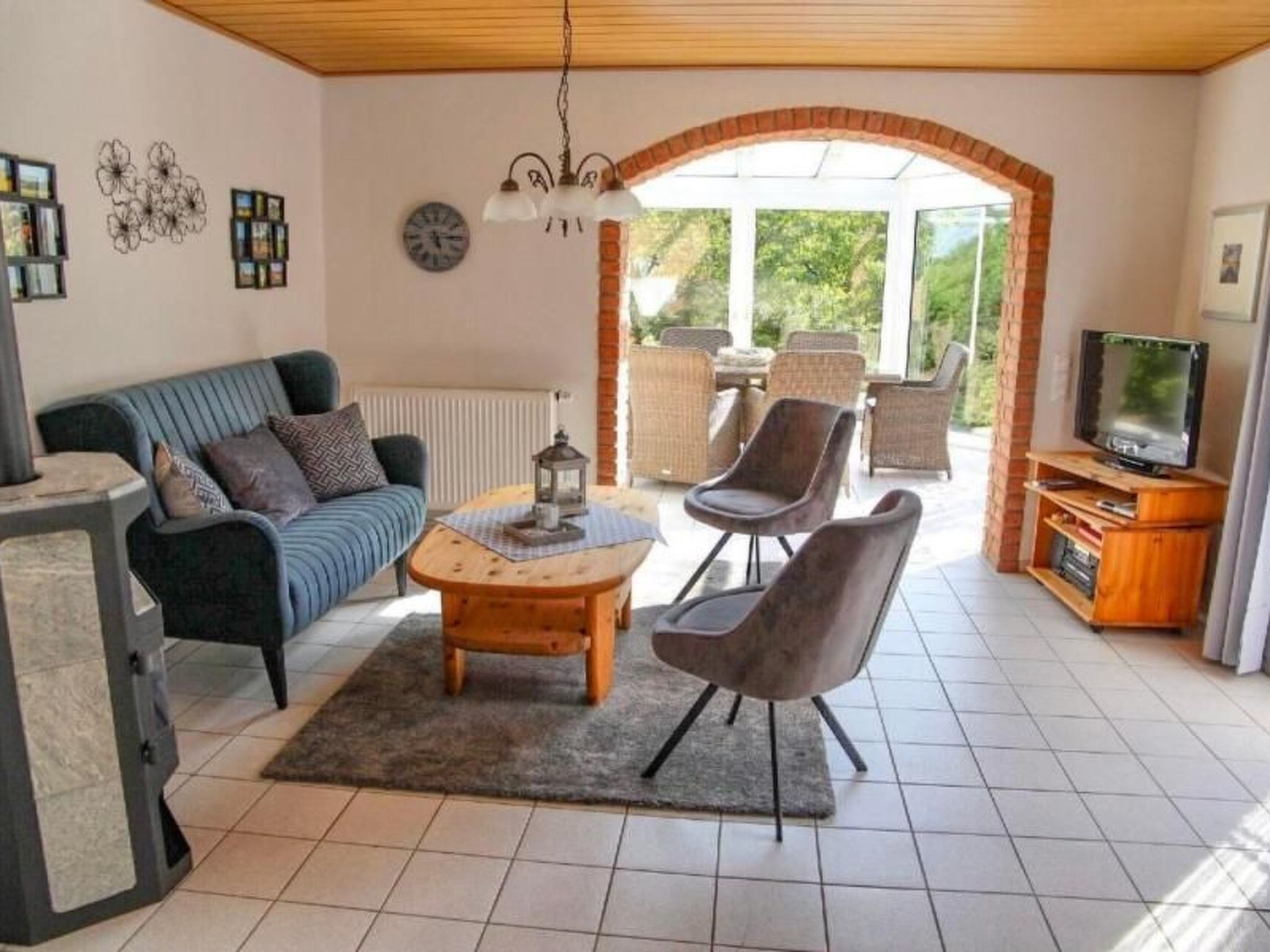 A living room with a sofa, chairs, a coffee table, a TV, and a fireplace.