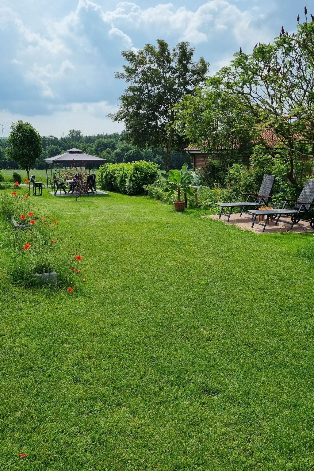 A well-maintained lawn with outdoor seating and a gazebo.