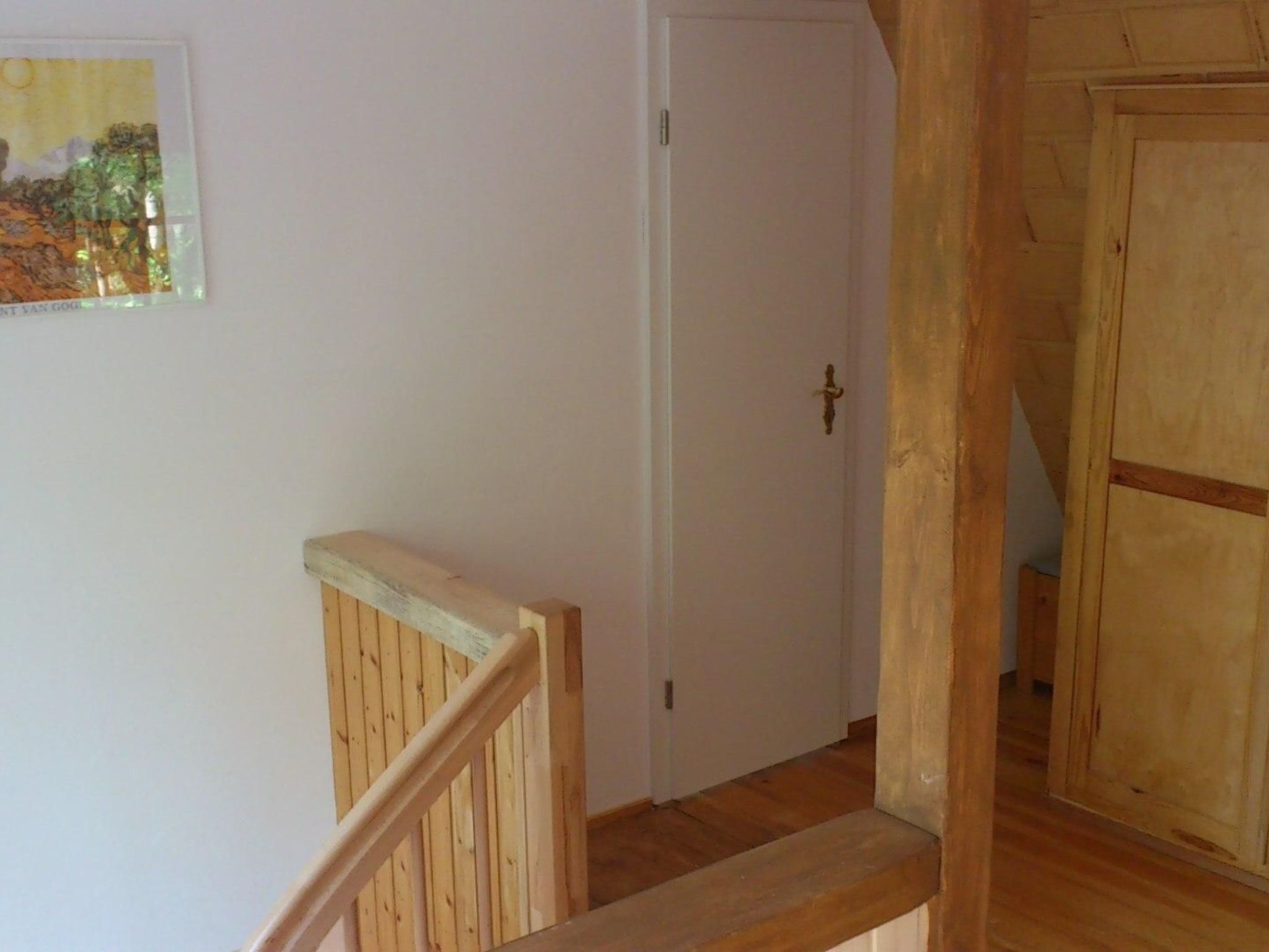 A wooden staircase with a white door at the top.