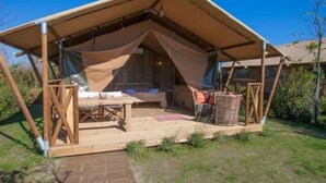 A wooden cabin with a pitched roof and a covered porch area. - Safarizelt in Hohenlychen mit Garten und Grill by Interhome (Lychen)