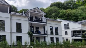 A multi-story residential building with balconies, a paved driveway, and surrounding greenery. - Strandblick by Interhome (Binz)