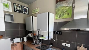 Una cocina compacta con microondas, pileta, hornilla y un reloj digital que muestra las 17:41.