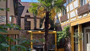 Un patio con suelo de adoquines, una palmera y edificios de arquitectura tradicional.