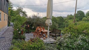 A patio with outdoor furniture, a pergola, and a garden area with various plants and flowers. - Wohnung in Bad Gottleuba by Interhome (Bad Gottleuba)