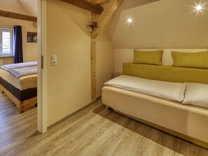A bedroom with a wooden ceiling, a bed with white bedding, and a window with curtains. - Heuschober by Interhome (Marktheidenfeld)