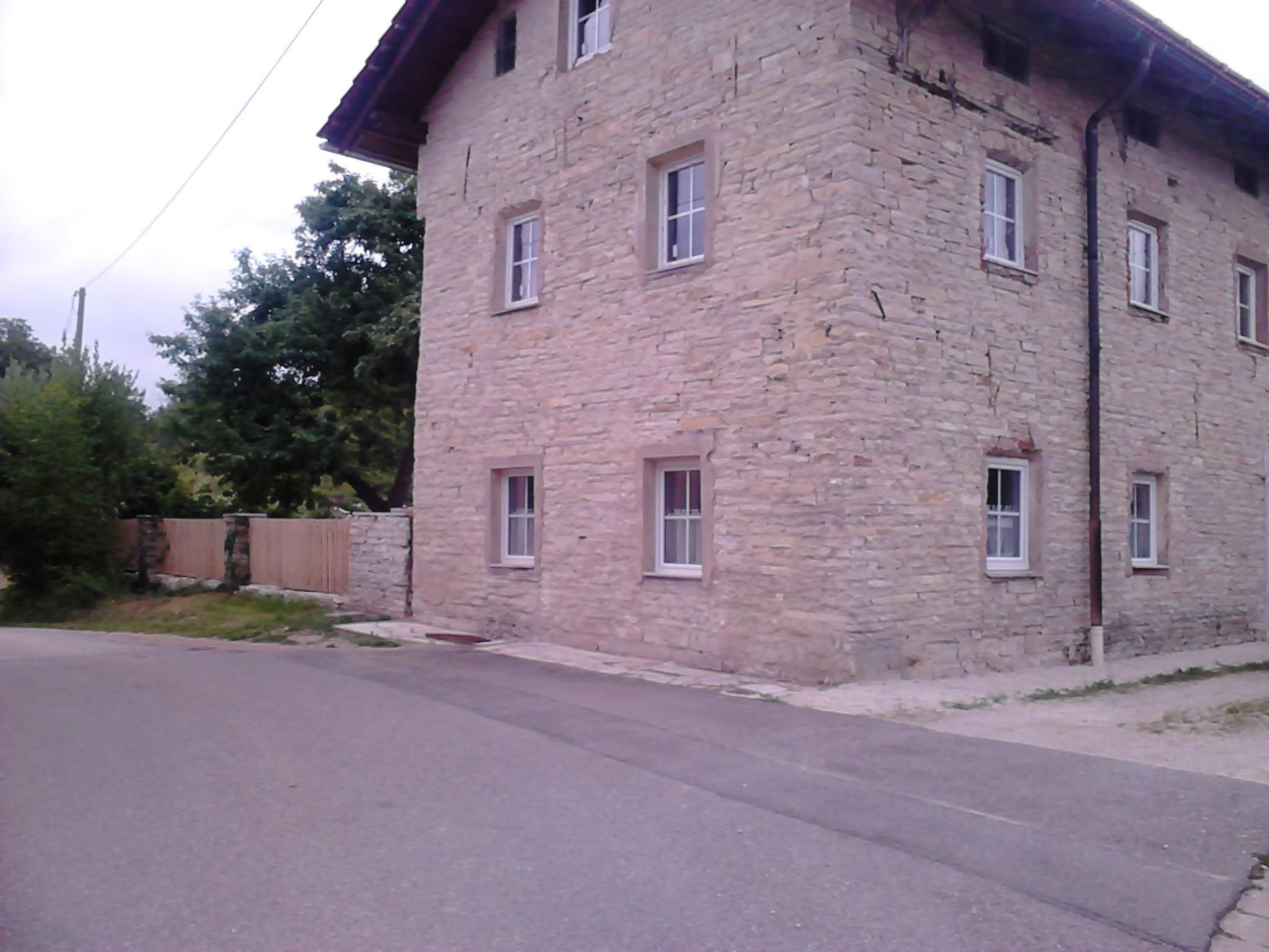 Un bâtiment en pierre doté de nombreuses fenêtres et d’un toit plat.