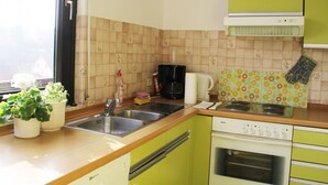 Een keuken met een Bosch oven, een koffiezetapparaat en een spoelbak.