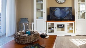 Ein Wohnzimmer mit Fernseher, Schränken und einem Vogel als Wanddekoration.