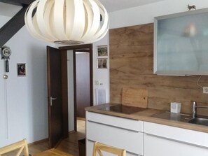 Een koelkast, een oven, een vaatwasser, kookgerei, borden en bestek