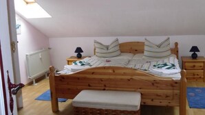 A bedroom with a wooden bed, two bedside tables with lamps, a radiator, and a skylight. - in Gründerzeitvilla in Strandnähe by Interhome (Ahlbeck)