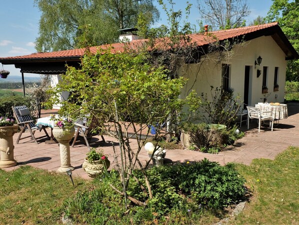 A rustic house with a tiled roof, a patio with outdoor furniture, and a garden area. - Ferienhäuschen bei Stockau II by Interhome (Weidenberg)