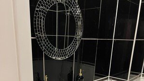 A bathroom with a white sink, a mirror, and a toilet. - Central location, 10 mins away from London Winter Wonderland (London)