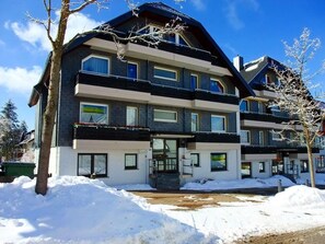 Ein mehrstöckiges Hotel mit modernem Design, mit Balkonen und großen Fenstern.
