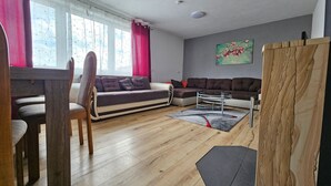 Ein modernes Wohnzimmer mit einer Couch, einem Esstisch und einem Couchtisch.