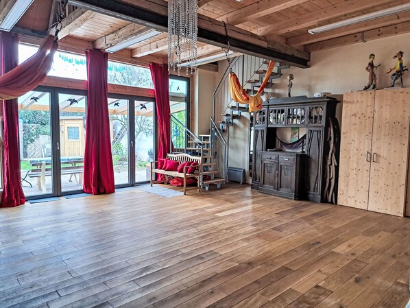 A spacious room with a wooden floor, a hammock, a staircase, and a large cabinet. - Fh Kimmelsbacher Hof by Interhome (Kimmelsbach)