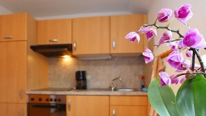 Una cucina con mobili in legno, un fornello e una macchina per il caffè.