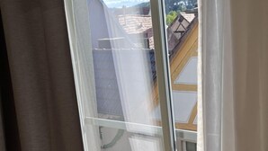 Ein Fenster mit Blick auf ein Dach und einen klaren Himmel.