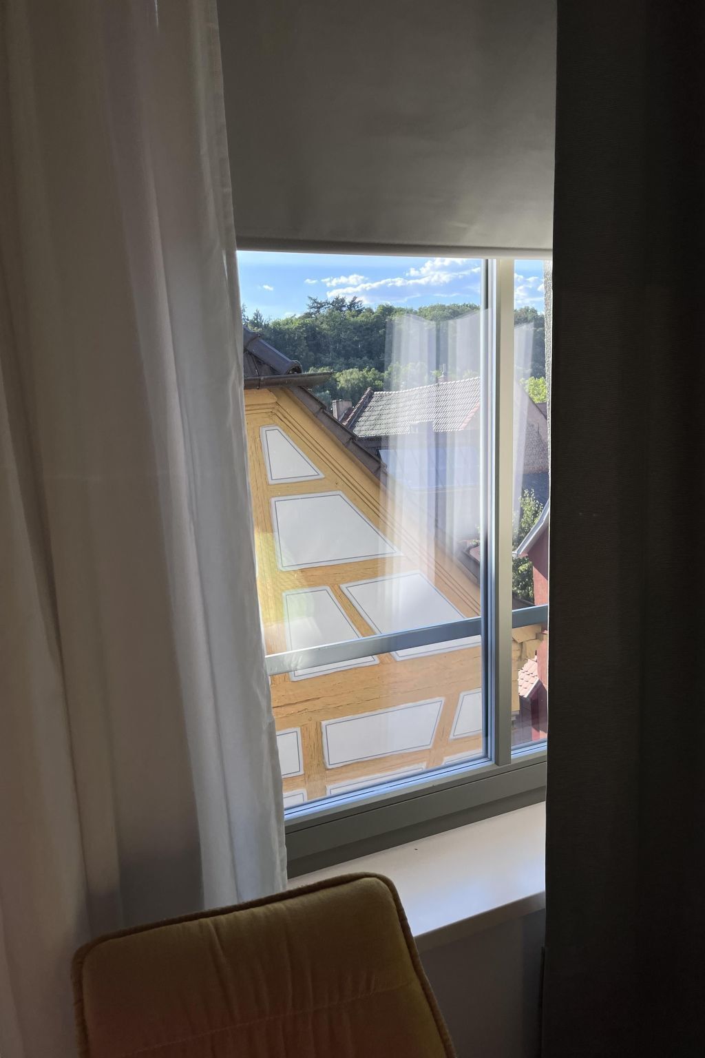 Une pièce dotée d’une grande fenêtre donnant sur un quartier résidentiel.