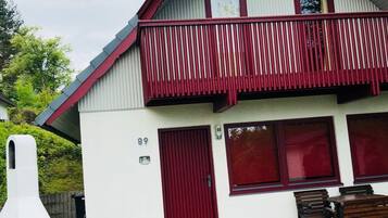 Ein zweigeschossiges Gebäude mit einem roten Balkon, einer Satellitenschüssel und einem Schild mit der Nummer 89.