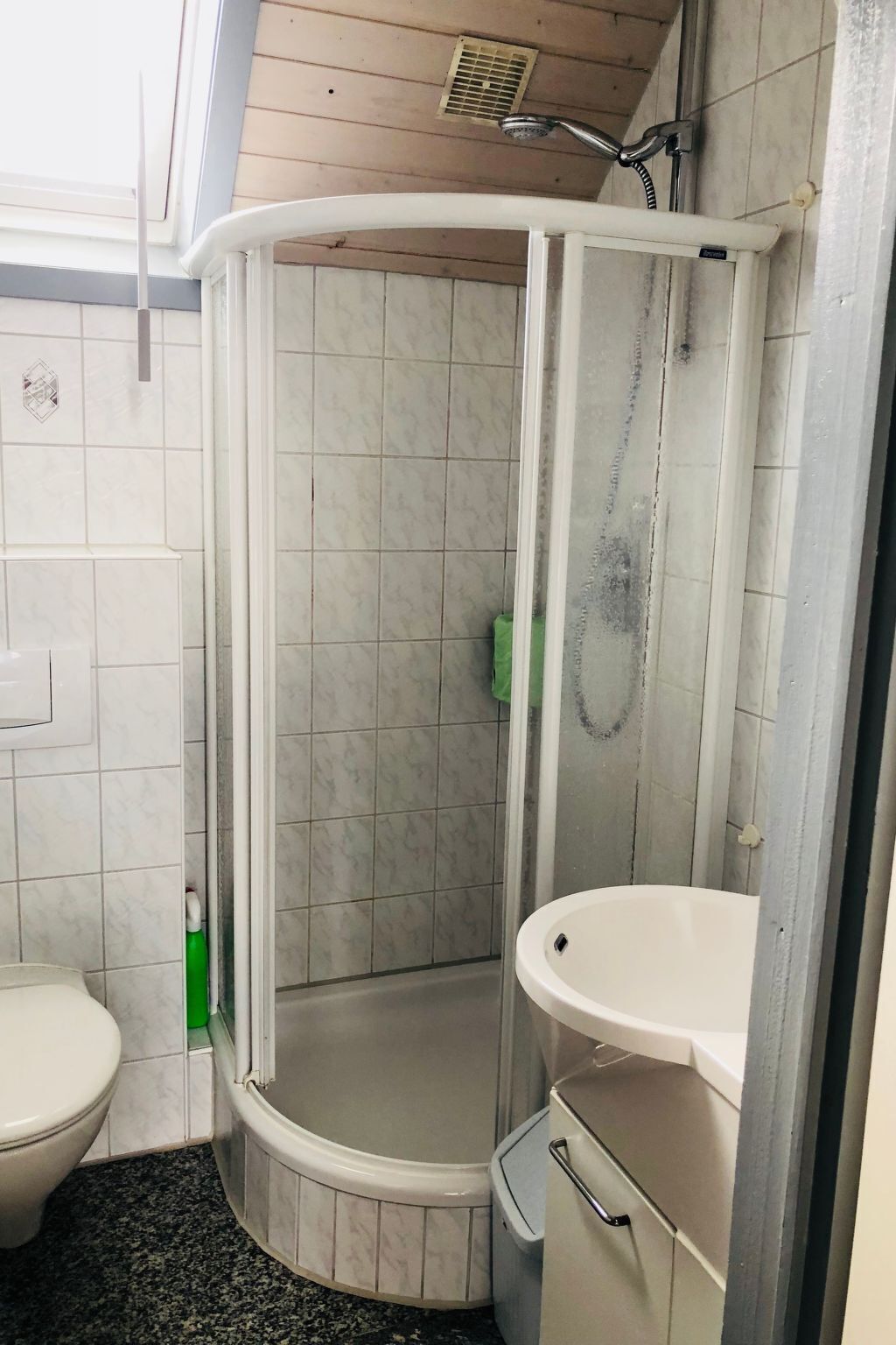 A bathroom with a shower, toilet, and sink.