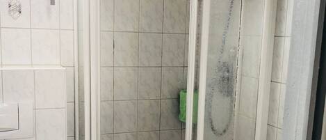 A bathroom with a shower, toilet, and sink.