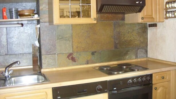 Una cocina con estufa, horno y pileta.