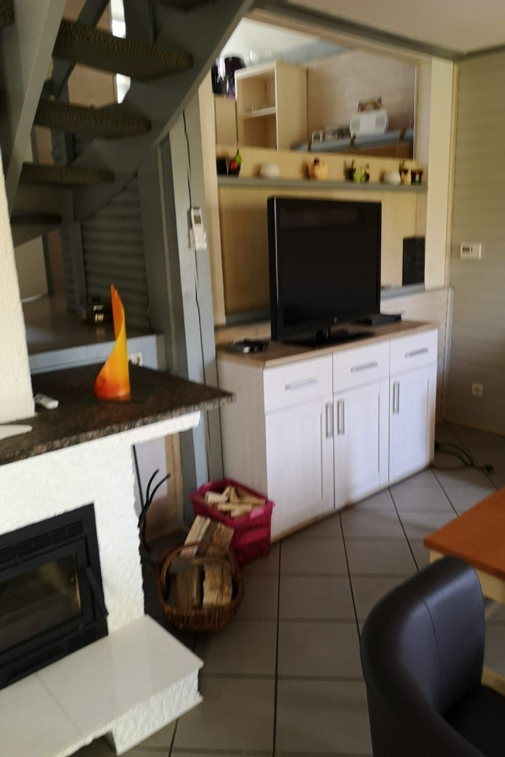 Een compact woongedeelte met een kitchenette, een flatscreen televisie en een eethoek.