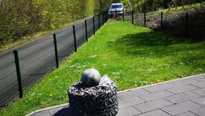 A paved pathway with a stone structure in the foreground, a fence, and a vehicle in the background. - Stausee in Kirchheim Seepark by Interhome (Kirchheim)