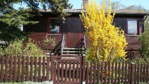 A wooden house with a red door and a small porch. - Hetzberghaus by Interhome (Laubach)