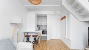 Um apartamento moderno com sala de estar, cozinha e escada.
