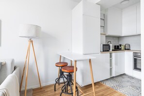 A modern kitchen with white cabinets, a microwave, a kettle, and a coffee maker on the countertop. - Blueground | Ville Haute, view, nr Grand Ducal Palace (Luxembourg)