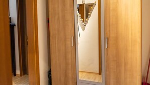 A wooden wardrobe with a mirrored door and a small mirror on the inside. - mit zwei Schlafzimmern und Terrasse by Interhome (Weißenstadt)
