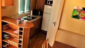 A compact kitchen with a sink, microwave, and refrigerator. - Stacaravan Rozika Slowenien by Interhome (Slovenj Gradec)