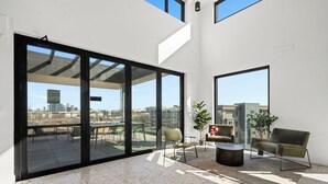 Un balcon spacieux offrant une vue sur la ville, un mobilier moderne et une grande fenêtre.