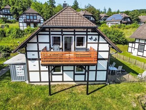 A traditional half-timbered house with a balcony, a small attached shed, and a fenced yard. - Kellerwald by Interhome (Frankenau)