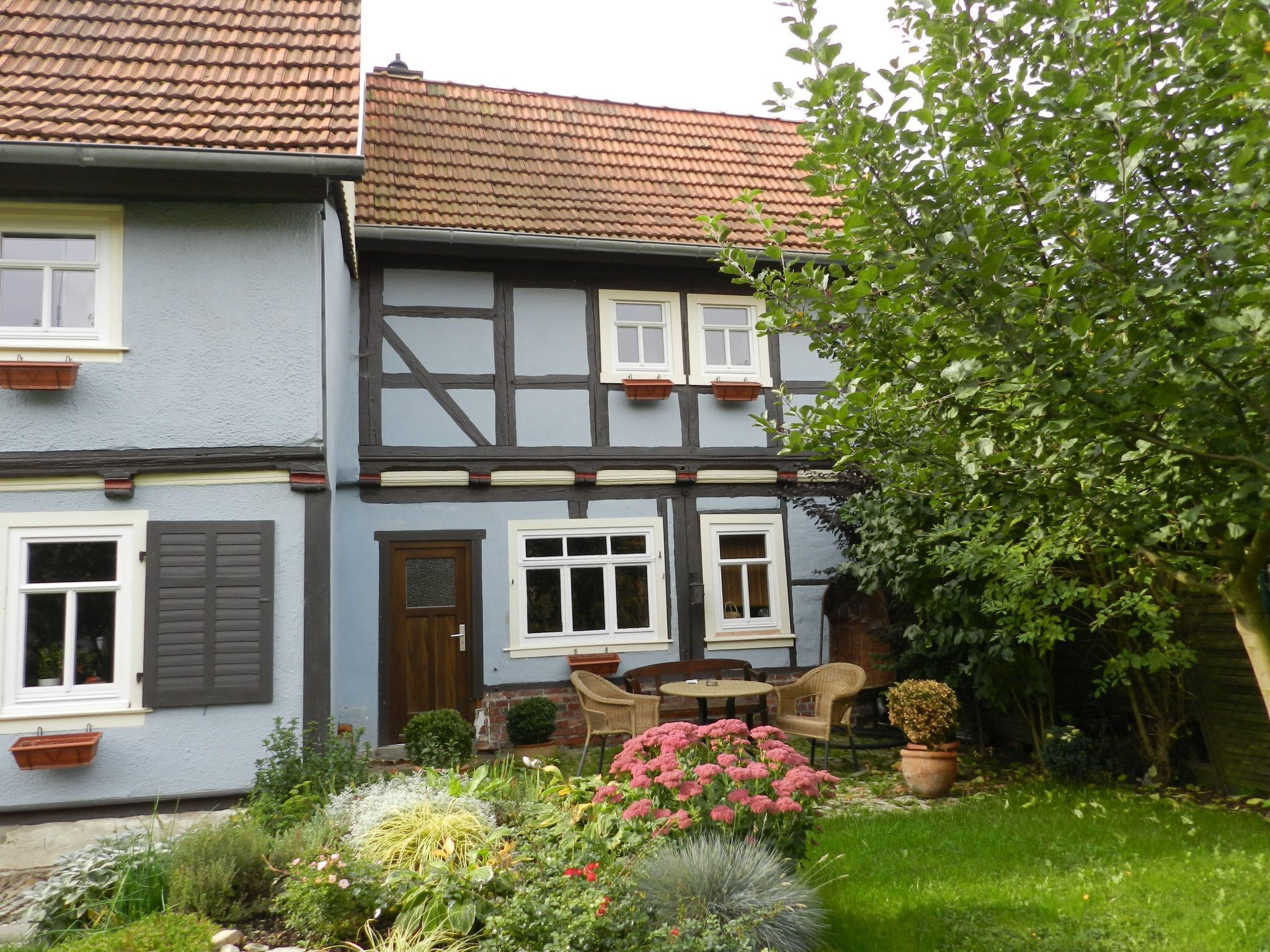Ein traditionelles Fachwerkhäuschen mit einem Vorgarten.